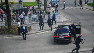 Sicherheitsbeamte laufen um eine Limousine mit Robert Fico herum. | REUTERS