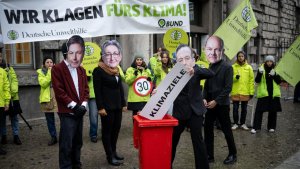 Umweltschützer protestieren mit Masken, die Gesichter deutscher Regierungsmitglieder zeigen, gegen die Klimaschutzpolitik. | dpa