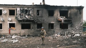 Ein ukrainischer Polizist inspiziert ein beschädigtes Gebäude in der Stadt Wowtschansk. | EPA