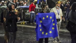 Ein Demonstrant steht mit einer EU-Flagge vor einer Polizeisperre während eines Protestes der Opposition gegen das 